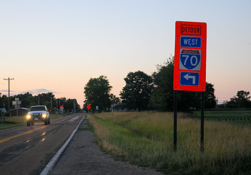 A vehicle passes a detour sign on I-70